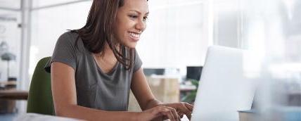 A woman working on a laptop with her hands on the keyboard